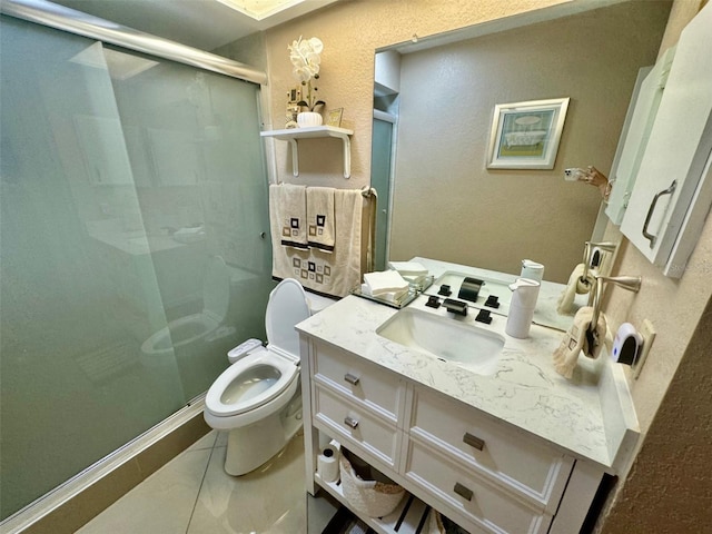 bathroom with a shower with door, vanity, toilet, and tile patterned flooring