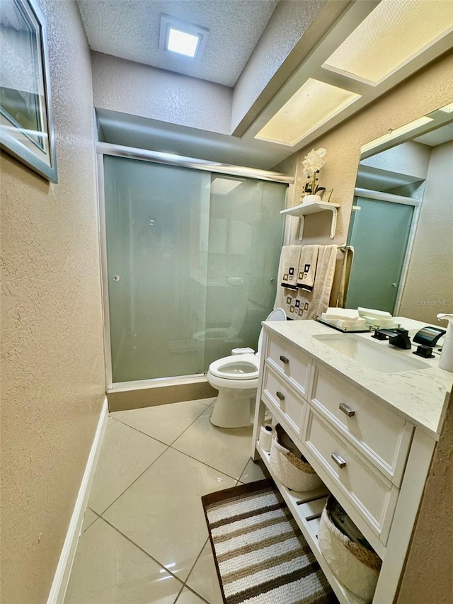 bathroom with a textured ceiling, vanity, an enclosed shower, toilet, and tile patterned floors