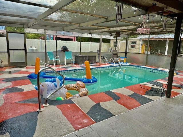 view of swimming pool with glass enclosure and a patio area