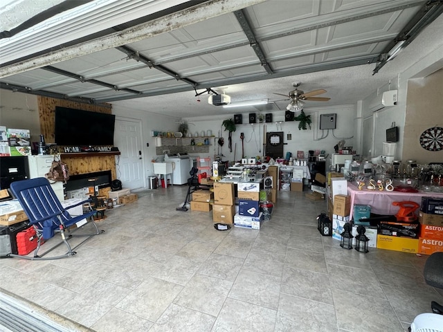 garage featuring ceiling fan, a garage door opener, and washer / dryer