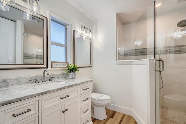 bathroom featuring toilet, an enclosed shower, wood-type flooring, and vanity