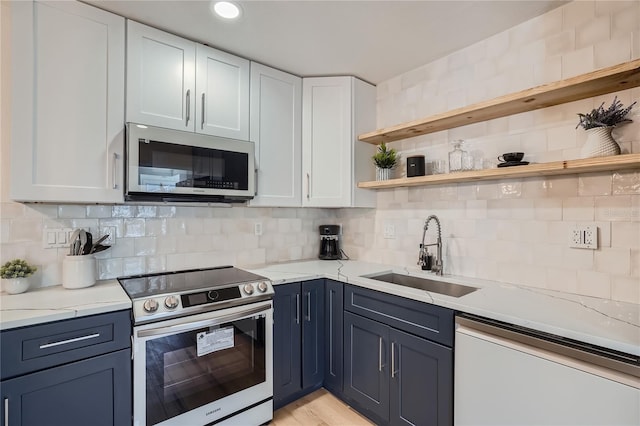 kitchen with backsplash, white cabinetry, sink, and appliances with stainless steel finishes