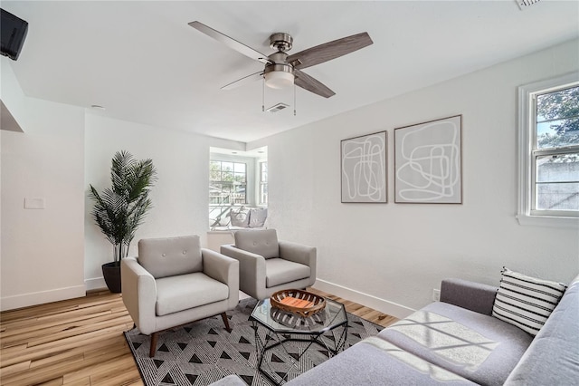 living room featuring light hardwood / wood-style flooring and ceiling fan