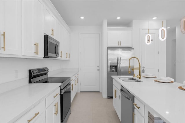 kitchen featuring appliances with stainless steel finishes, sink, light tile patterned floors, and white cabinets