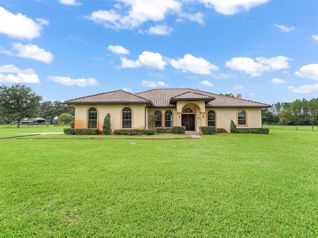 mediterranean / spanish-style home with a front lawn