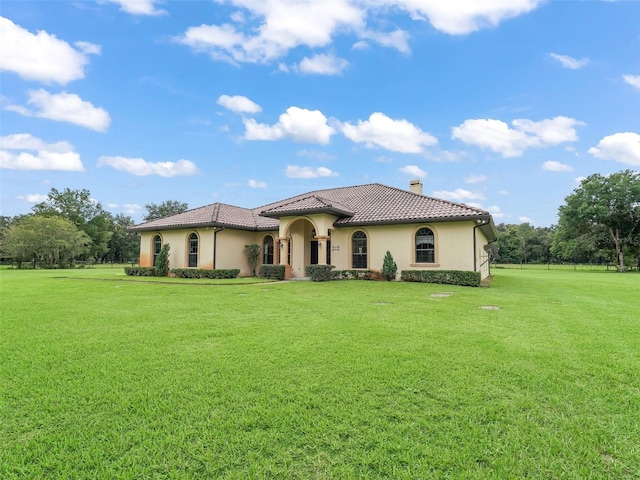 mediterranean / spanish home with a front yard