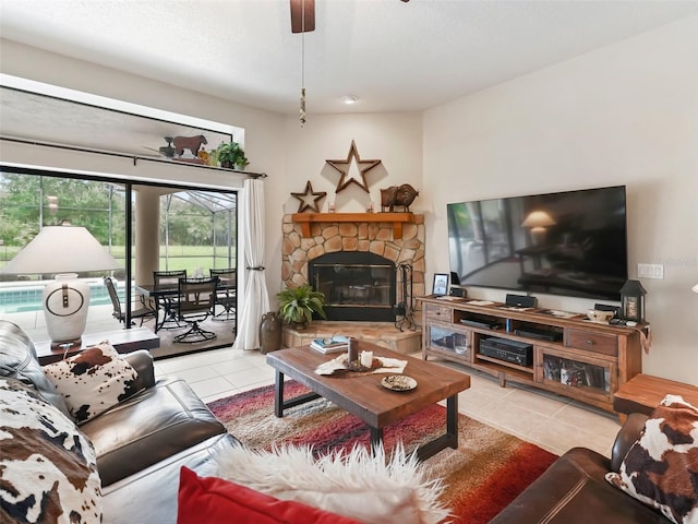 tiled living room featuring a fireplace and ceiling fan