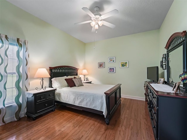 bedroom with ceiling fan and dark hardwood / wood-style flooring