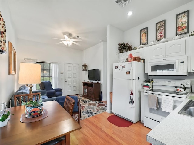 kitchen with light wood-type flooring, ceiling fan, white appliances, and white cabinets