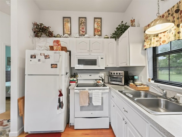 kitchen featuring sink, decorative light fixtures, light wood-type flooring, white appliances, and white cabinetry