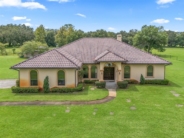 mediterranean / spanish-style house with a front yard