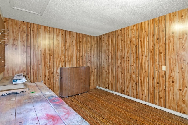 interior space with wood walls and a textured ceiling