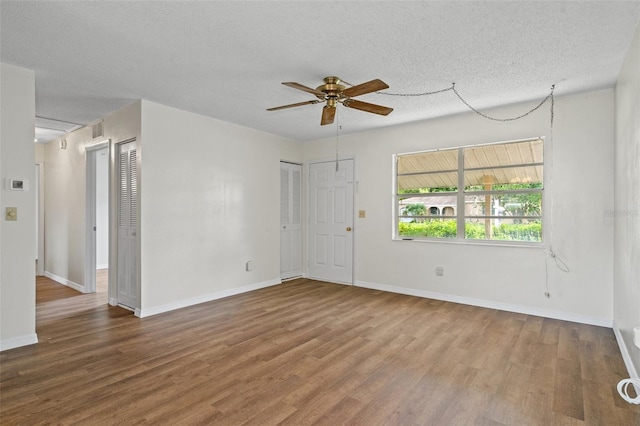 unfurnished room with ceiling fan, hardwood / wood-style floors, and a textured ceiling