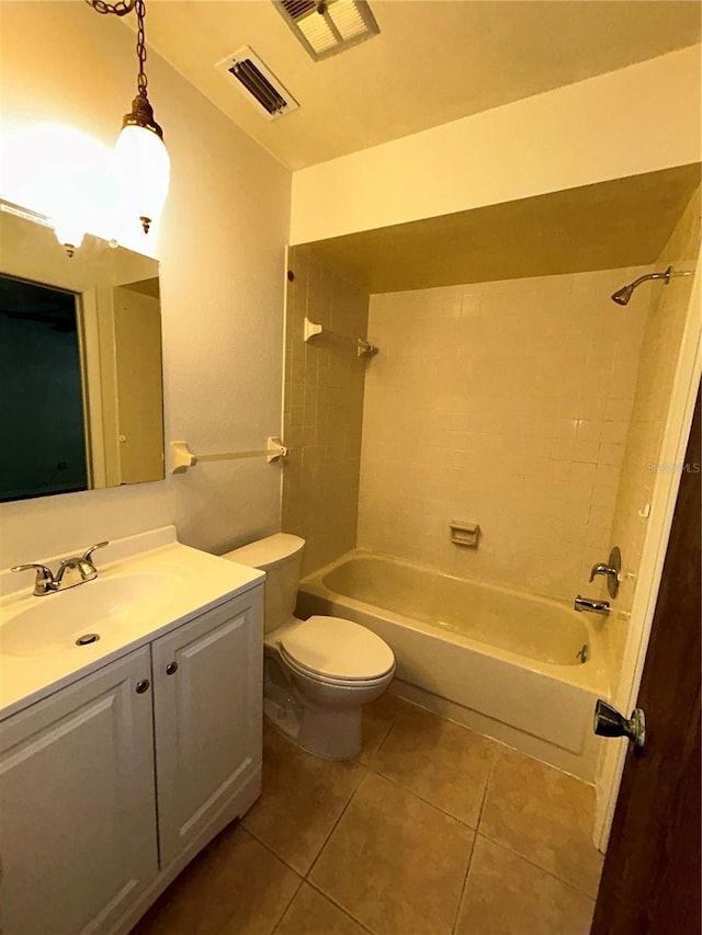 full bathroom with tile patterned flooring, tiled shower / bath combo, toilet, and vanity