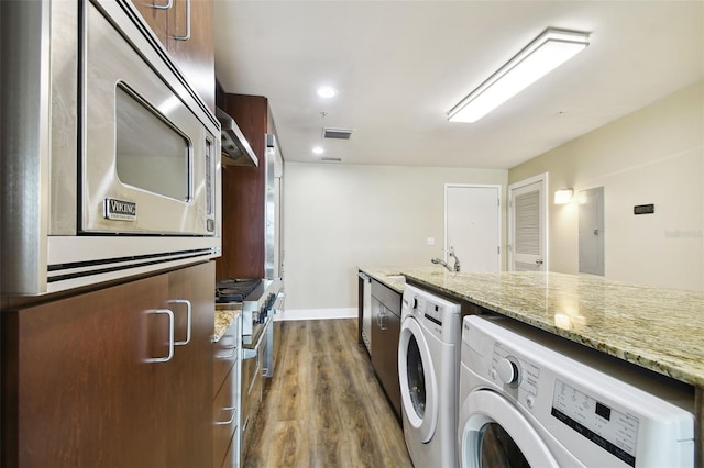 washroom featuring dark hardwood / wood-style flooring, washer and dryer, and sink