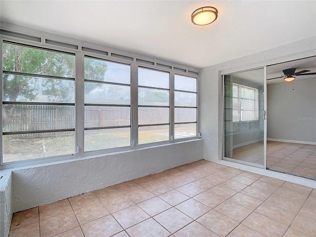 unfurnished sunroom featuring a wealth of natural light and ceiling fan