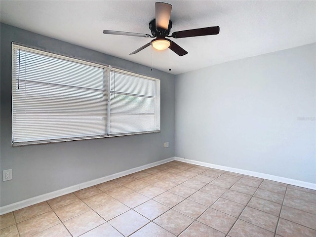 spare room featuring light tile patterned flooring, ceiling fan, and a healthy amount of sunlight