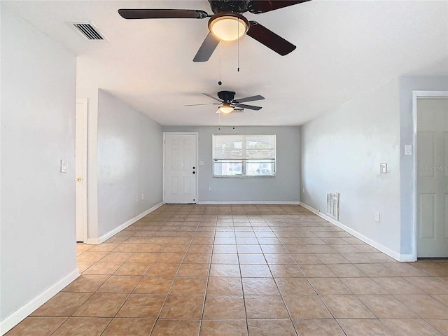 tiled spare room with ceiling fan