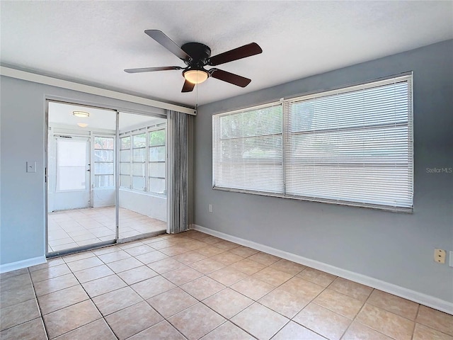 tiled spare room with ceiling fan