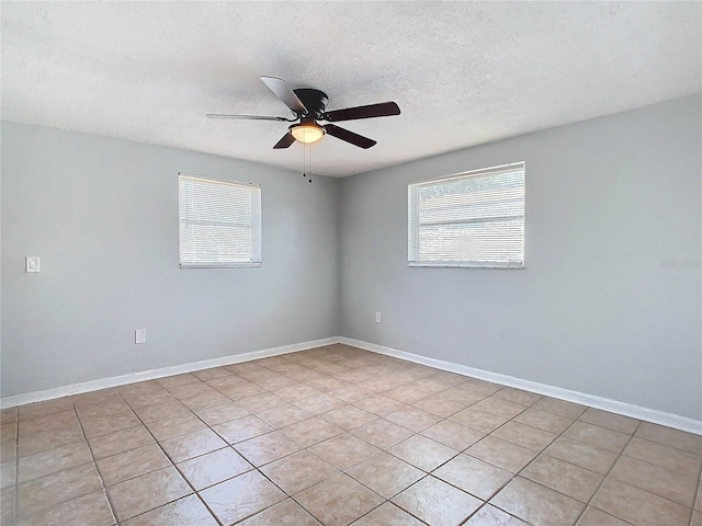 tiled spare room featuring a textured ceiling and ceiling fan