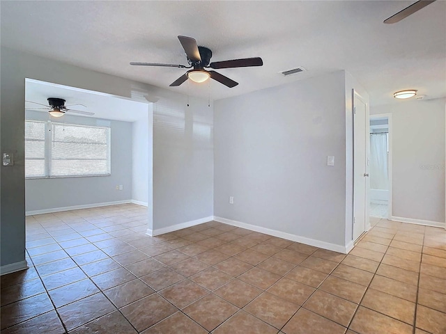 spare room featuring ceiling fan and tile patterned floors