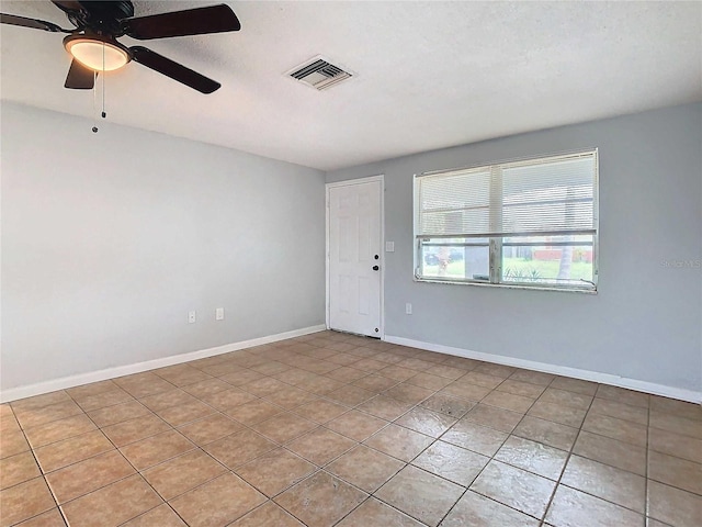 tiled spare room with ceiling fan