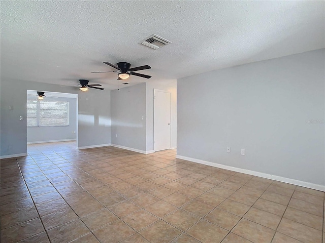 tiled empty room featuring ceiling fan and a textured ceiling