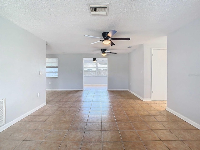 spare room with ceiling fan, light tile patterned floors, and a textured ceiling