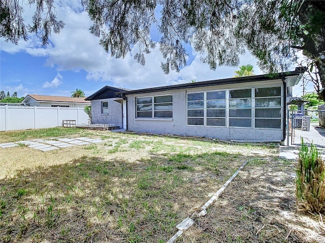 back of house with a patio and a lawn