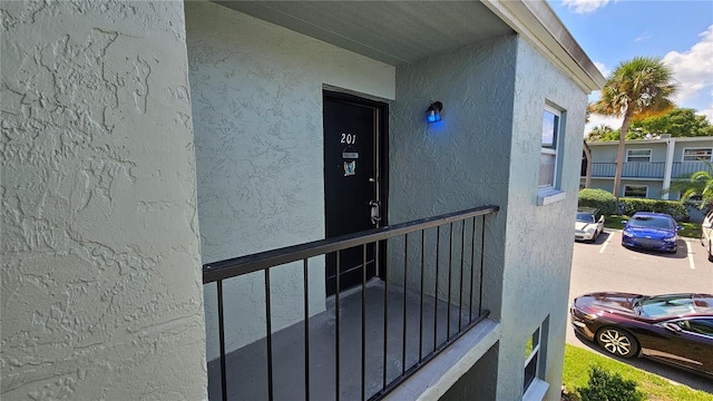 property entrance with uncovered parking and stucco siding