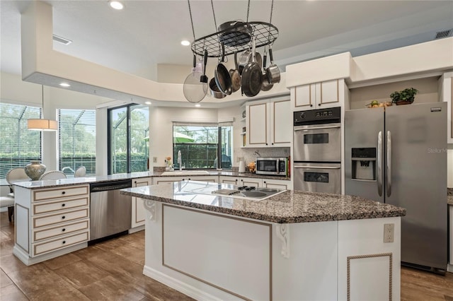 kitchen featuring a center island, sink, appliances with stainless steel finishes, and light hardwood / wood-style floors