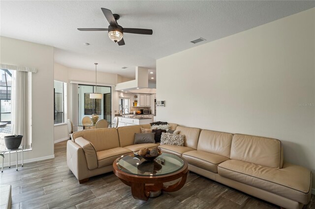 living room featuring ceiling fan, light wood-type flooring, and sink