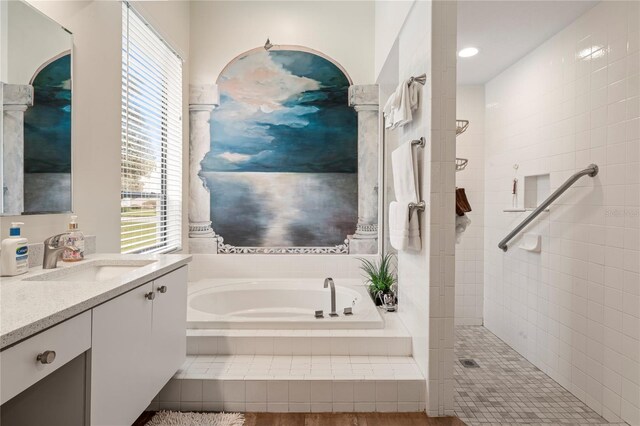 bathroom featuring wood-type flooring, shower with separate bathtub, and vanity