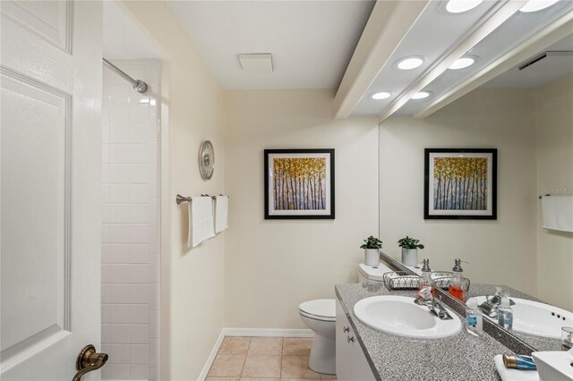 bathroom featuring tile patterned flooring, toilet, vanity, and walk in shower