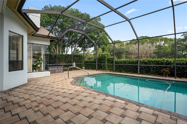 view of swimming pool featuring glass enclosure and a patio area