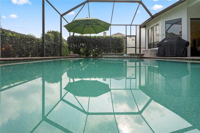 view of pool featuring glass enclosure and a grill