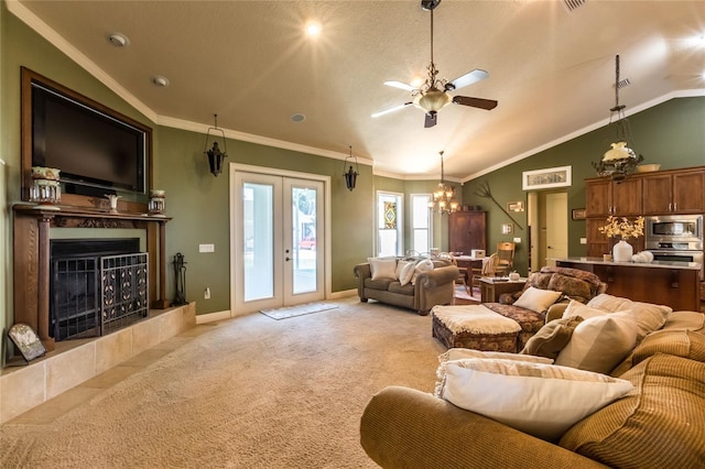 living room with ornamental molding, a fireplace, french doors, ceiling fan with notable chandelier, and light carpet