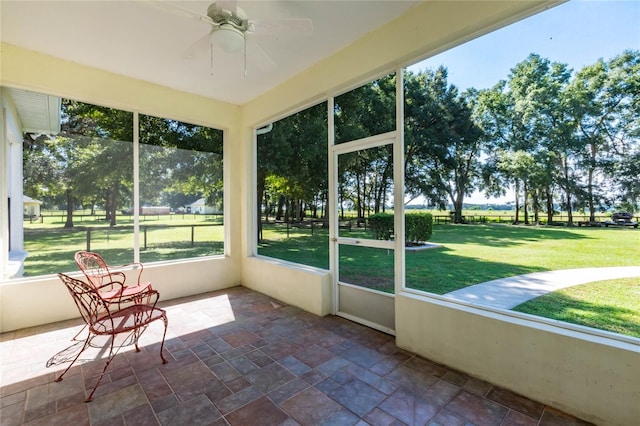 unfurnished sunroom featuring ceiling fan