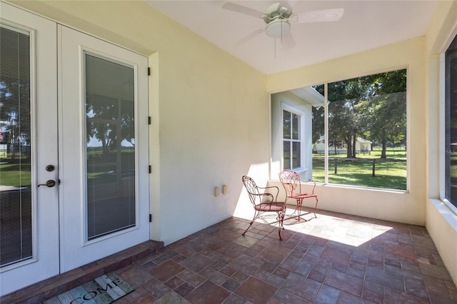 unfurnished sunroom with ceiling fan and french doors