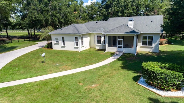 rear view of property with a yard and a sunroom