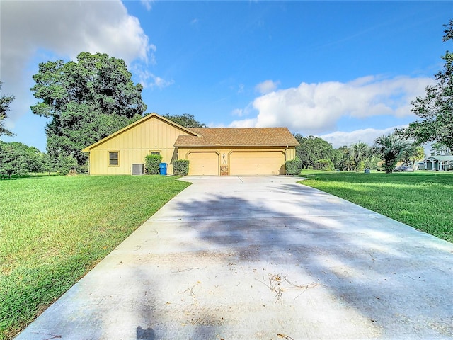 view of front of house featuring a front yard, central AC, and a garage