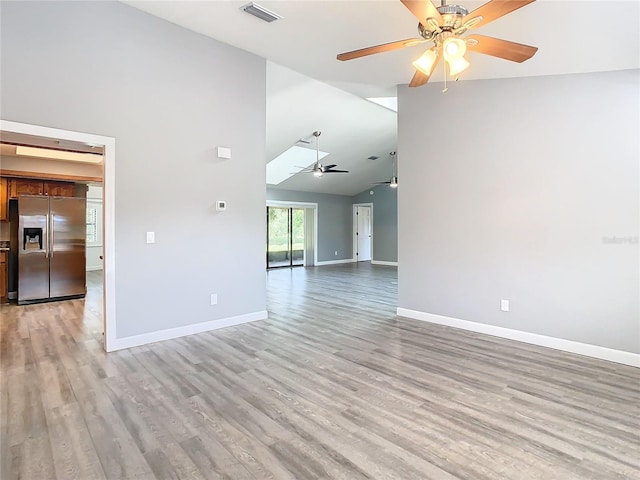 empty room with ceiling fan and light hardwood / wood-style flooring