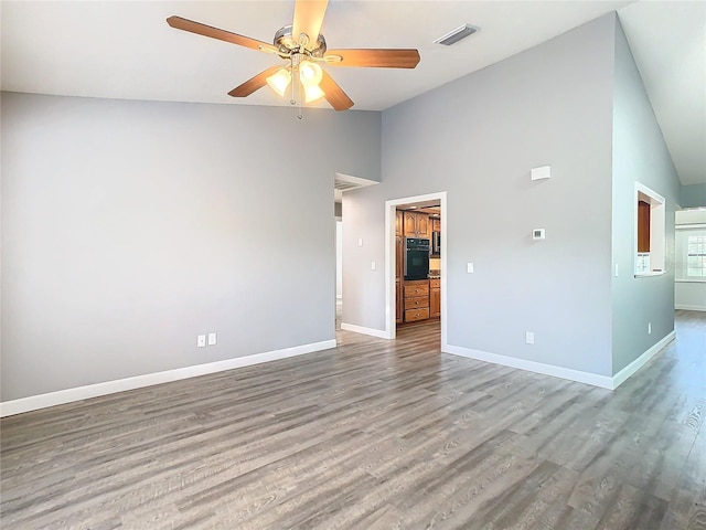 unfurnished room with ceiling fan, hardwood / wood-style flooring, and high vaulted ceiling