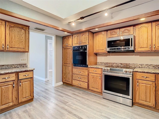 kitchen featuring light wood-type flooring, rail lighting, and stainless steel appliances