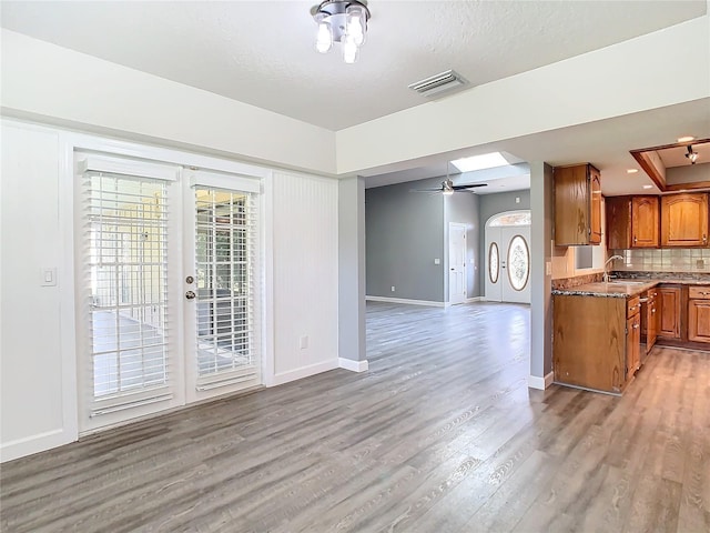 living room with hardwood / wood-style floors, sink, french doors, and ceiling fan