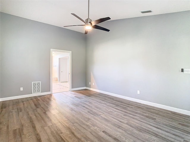 empty room with ceiling fan, lofted ceiling, and wood-type flooring