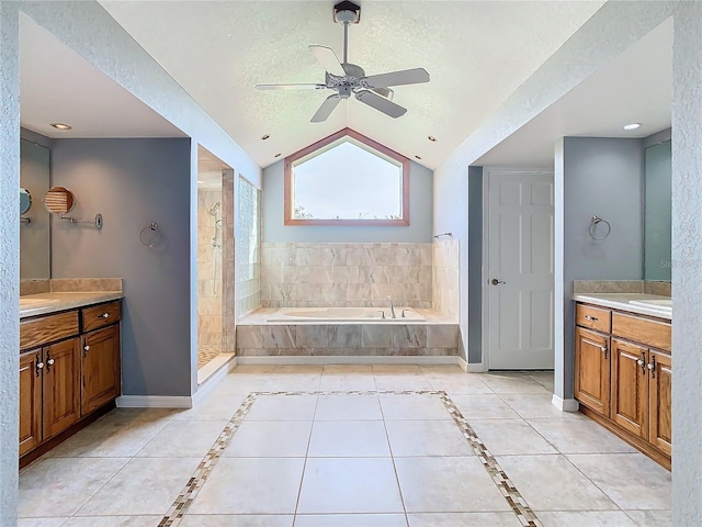 bathroom featuring ceiling fan, vaulted ceiling, a textured ceiling, and vanity