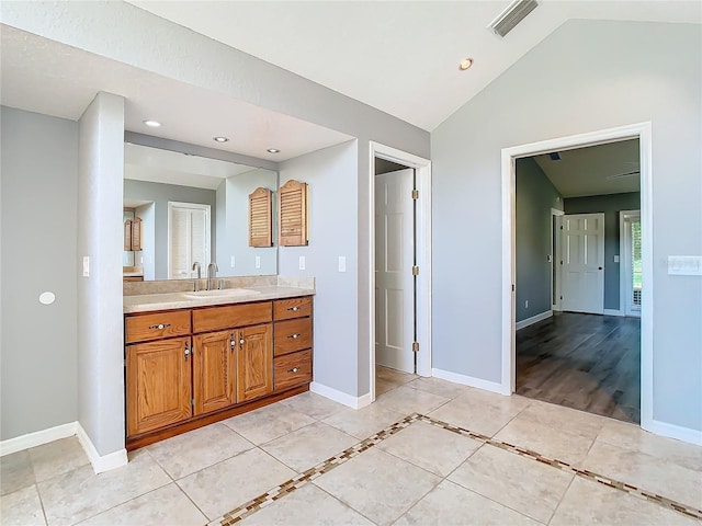 bathroom with hardwood / wood-style floors, vanity, and lofted ceiling