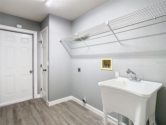 laundry area with hardwood / wood-style floors, sink, electric dryer hookup, and washer hookup