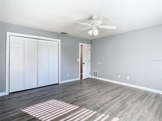 unfurnished bedroom with hardwood / wood-style floors, ceiling fan, and a closet